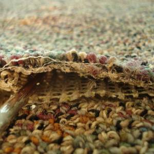 Carpet delamination showing separation between primary and secondary backing