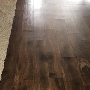 Peaked end joints in vinyl plank flooring (LVT) showing raised plank ends